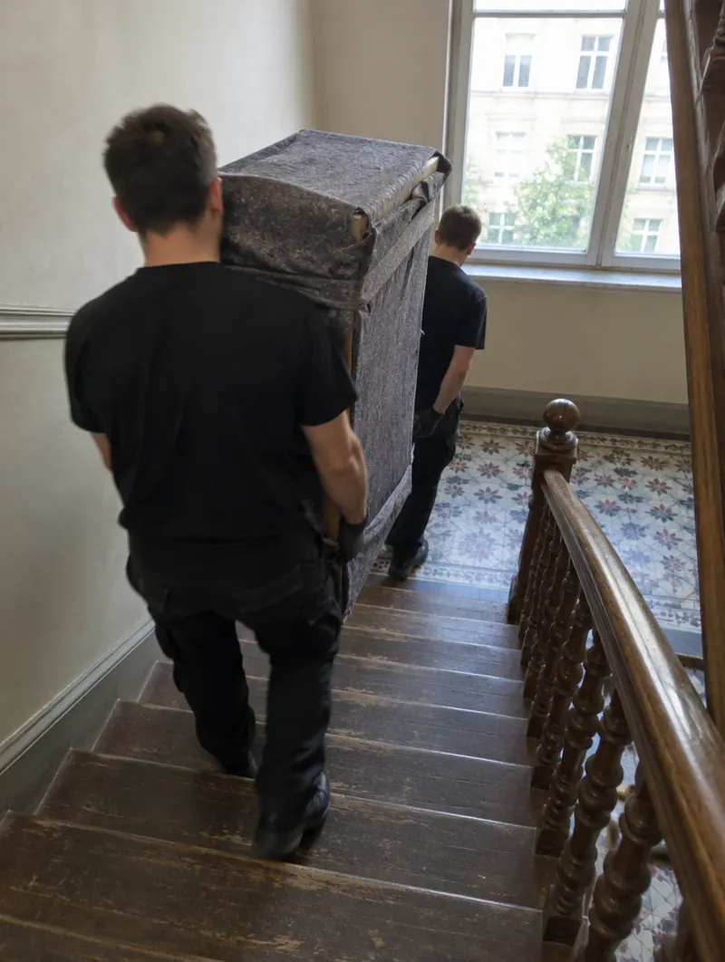 Umzugshelfer tragen einen Schrank durch ein Leipziger Altbau-Treppenhaus